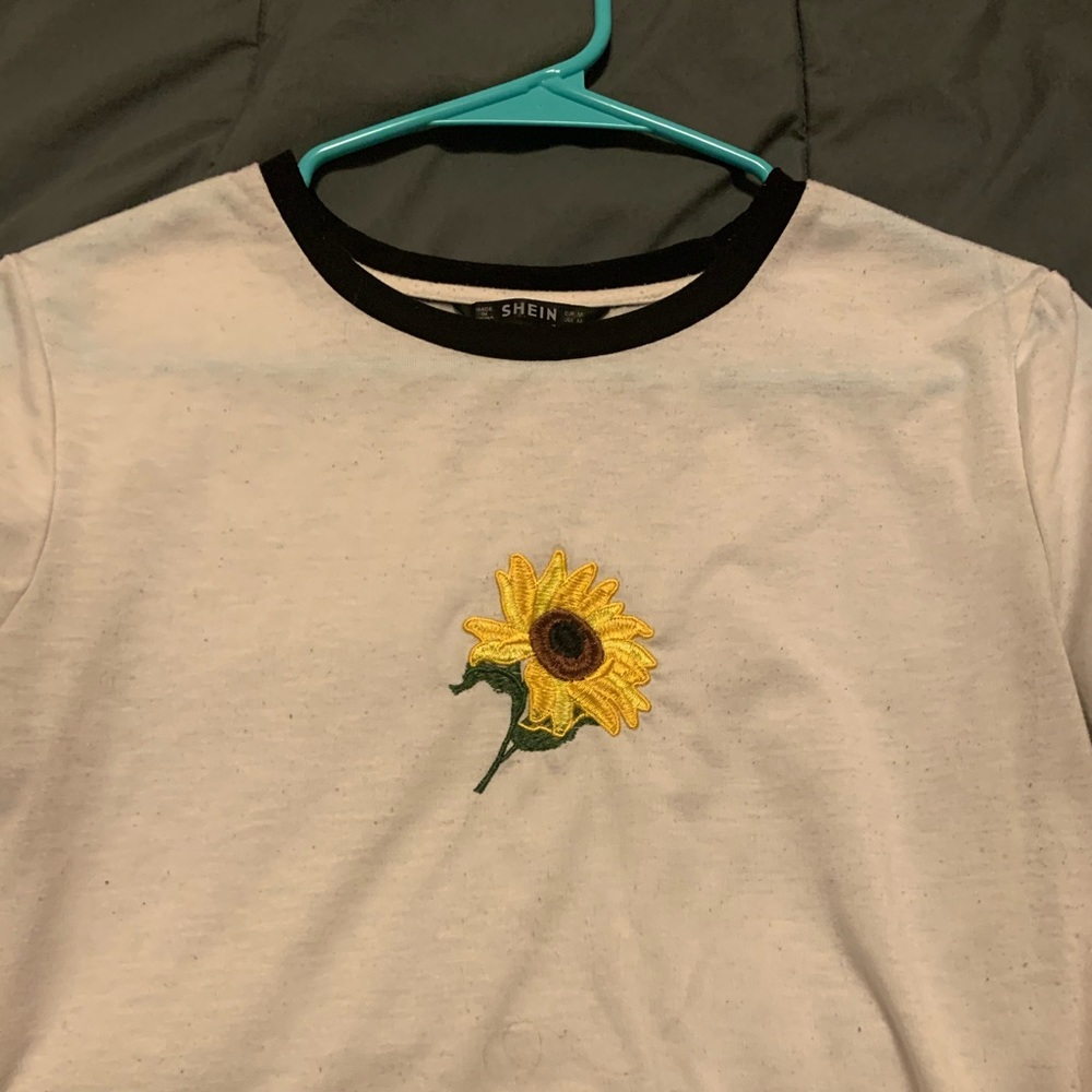 WHITE TOO WITH BLACK LINING SUNFLOWER ON IT.